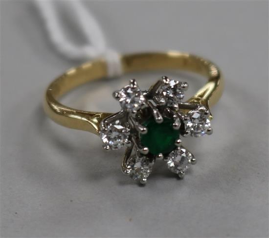 A modern 18ct gold, emerald and diamond cluster flower head ring, size O.